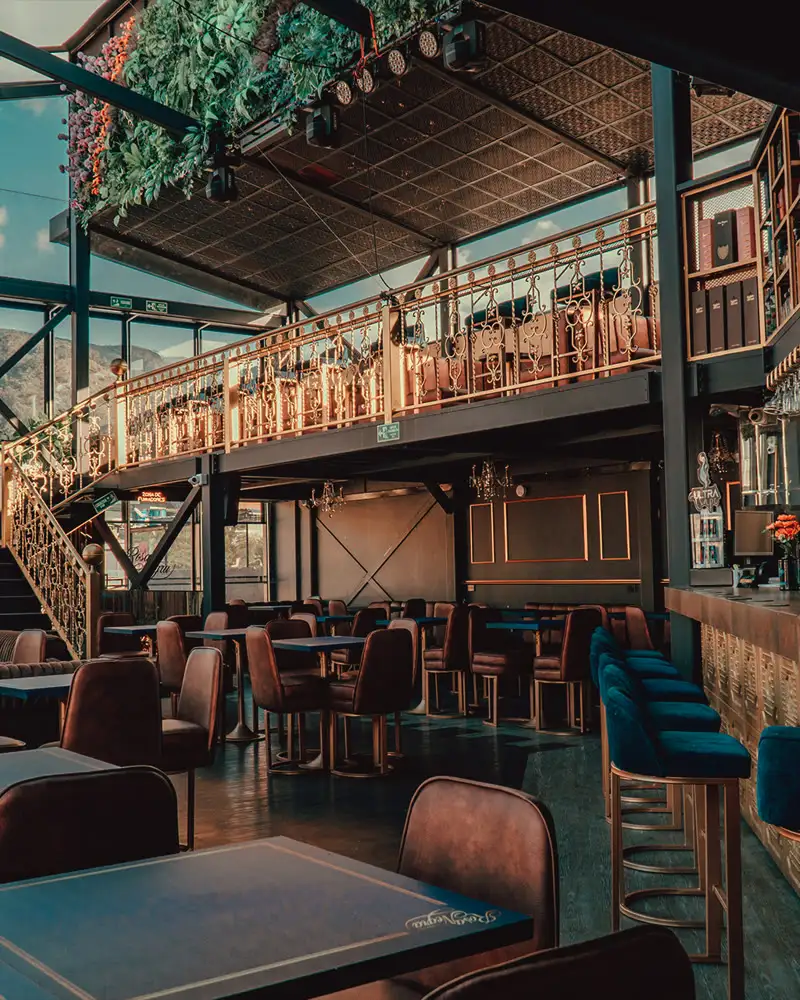Salón con escalera y doble altura en Rosa Negra Rooftop